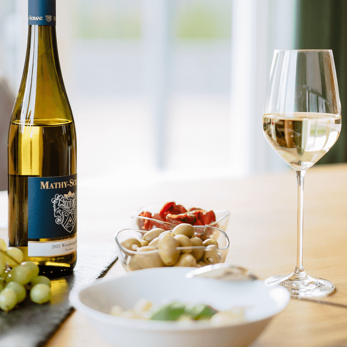 Glas Weißburgunder mit Weinflasche