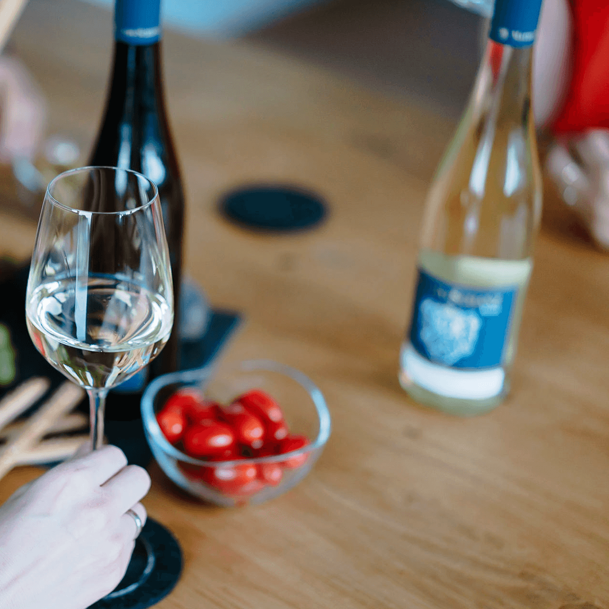 Weinflaschen auf Tisch mit Glas Weißwein